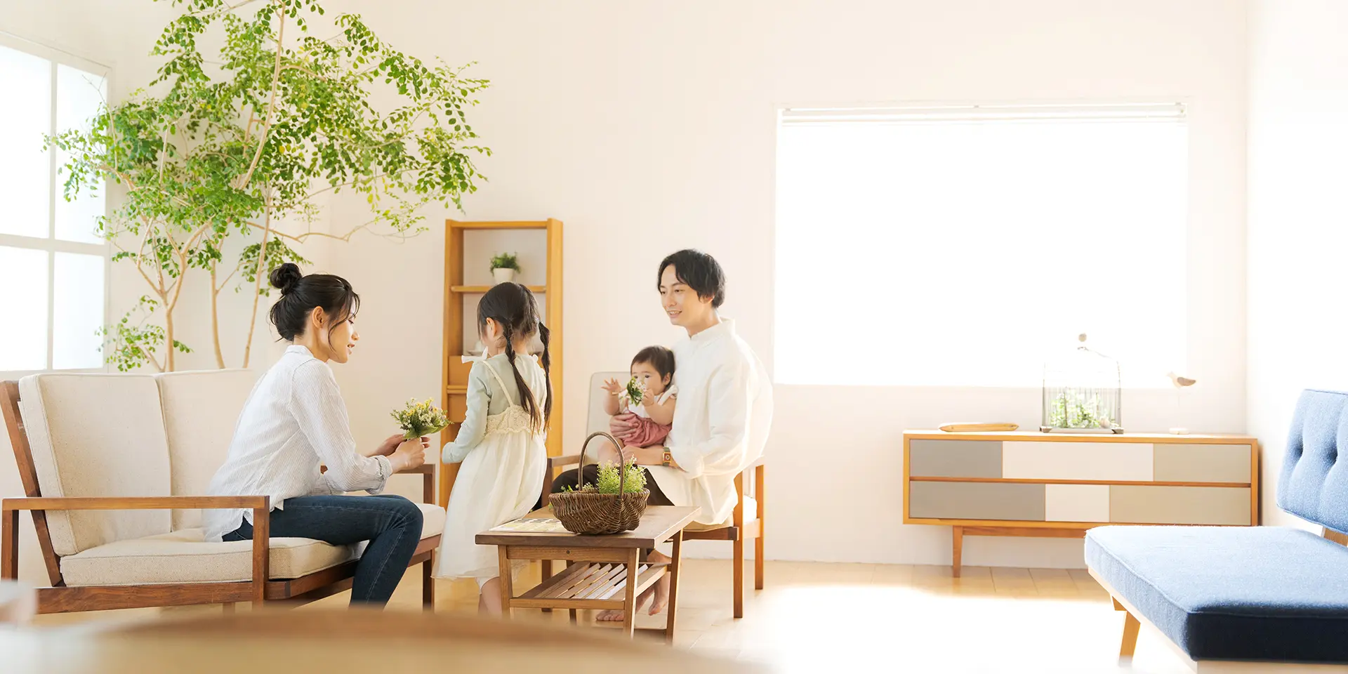 リビングに子供と両親がソファーに座っている